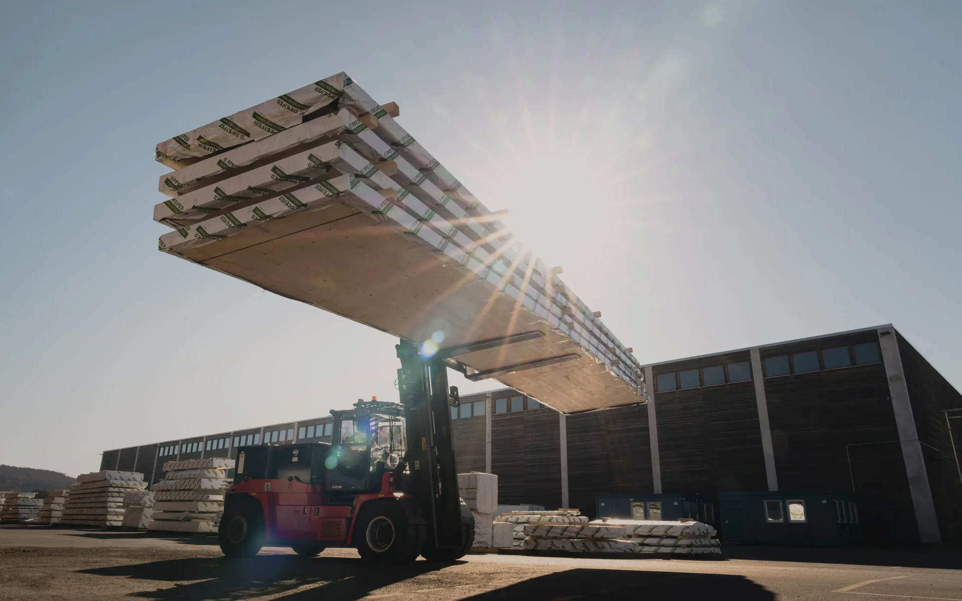 Gabelstapler transportiert CLT Brettsperrholz von Pfeifer in Lagerhalle